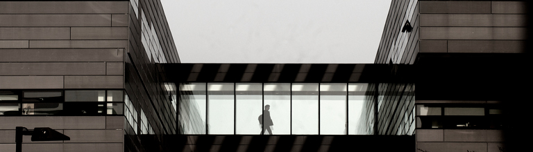 Student walking across walkway in Alan Turing Building